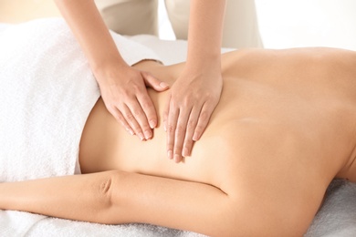 Relaxed woman receiving back massage in wellness center