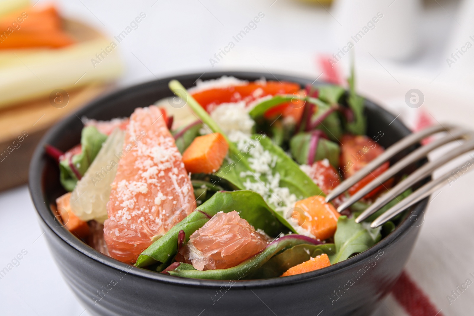 Photo of Delicious salad with pomelo, tomatoes and cheese in bowl, closeup