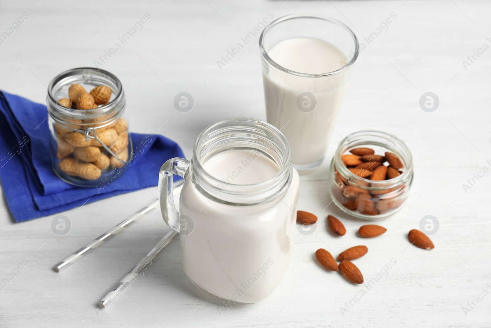 Photo of Almond and peanut milk with nuts on wooden background