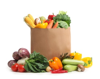 Photo of Fresh vegetables in paper shopping bag on white background
