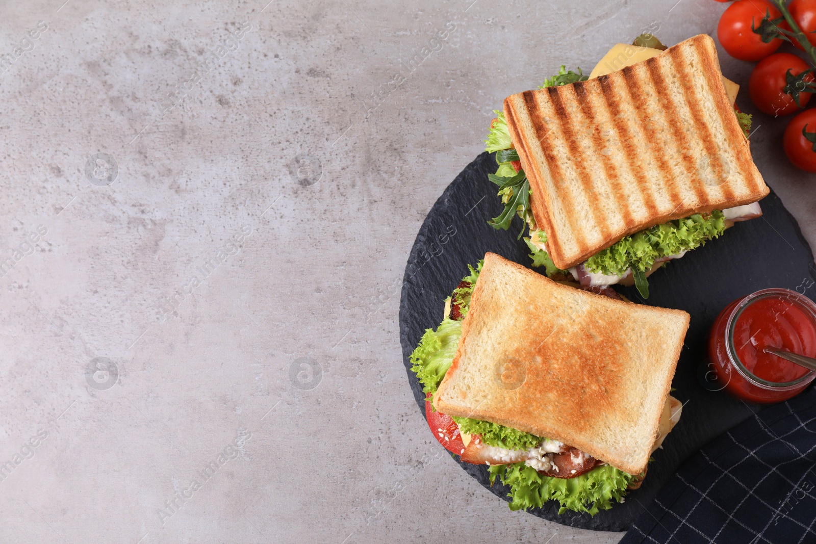 Photo of Tasty sandwiches served on grey table, flat lay. Space for text