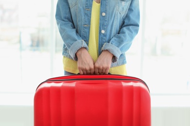 Photo of Young woman with suitcase indoors