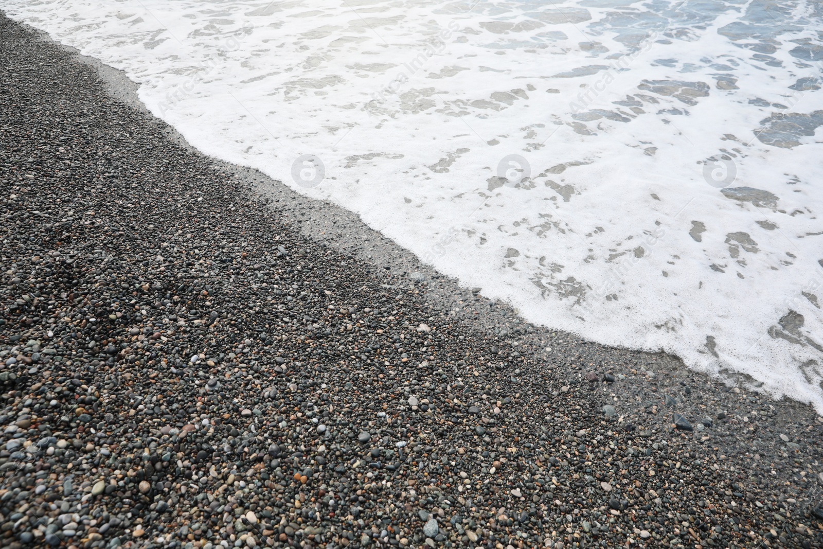 Photo of Picturesque view of beautiful sea wave on pebble beach