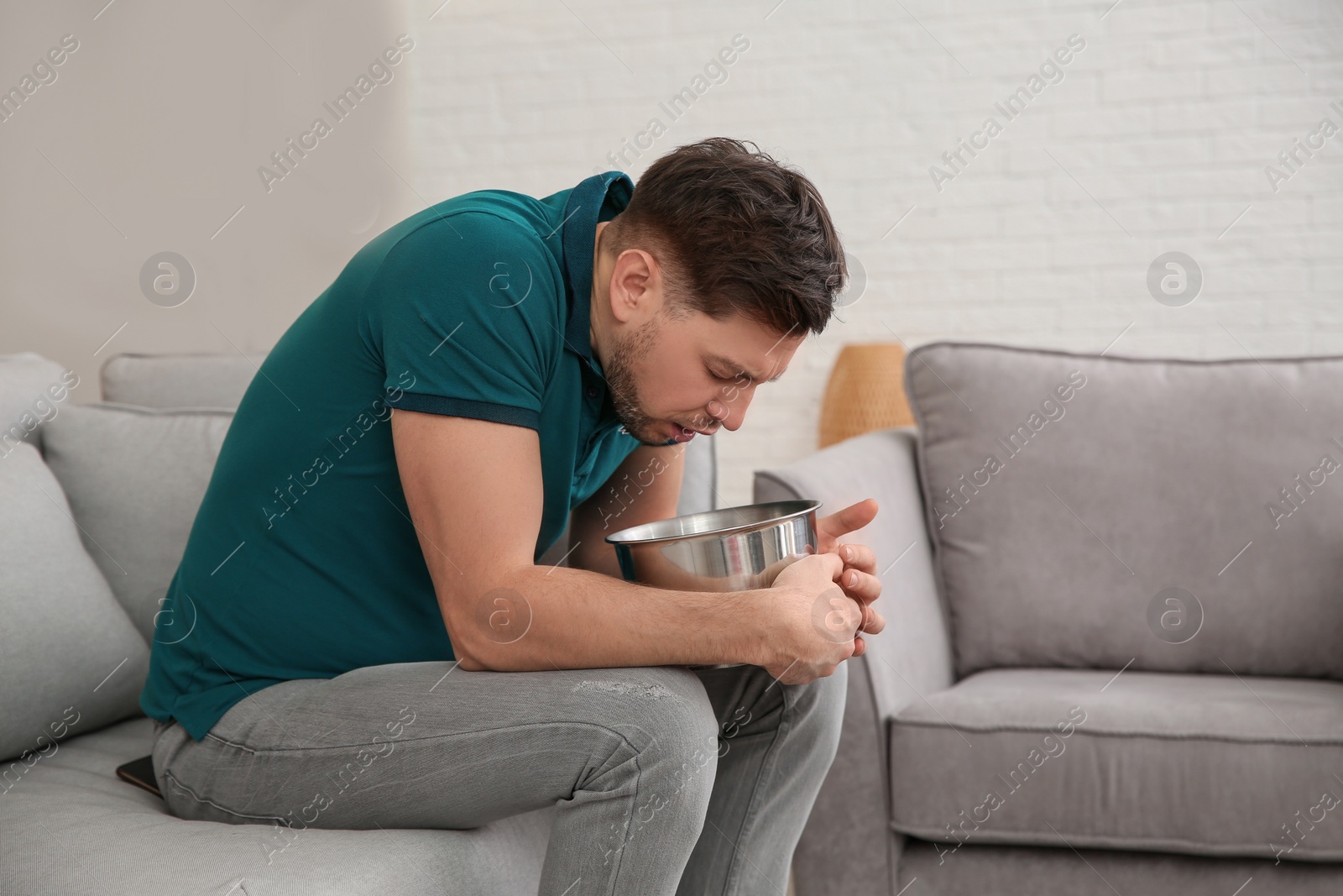 Photo of Young man having nausea at home. Space for text