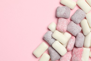 Photo of Different tasty colorful bubble gums on pink background, flat lay. Space for text