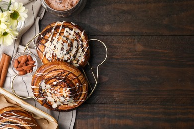 Photo of Sweet buns. Delicious rolls with toppings and almond on wooden table, flat lay. Space for text