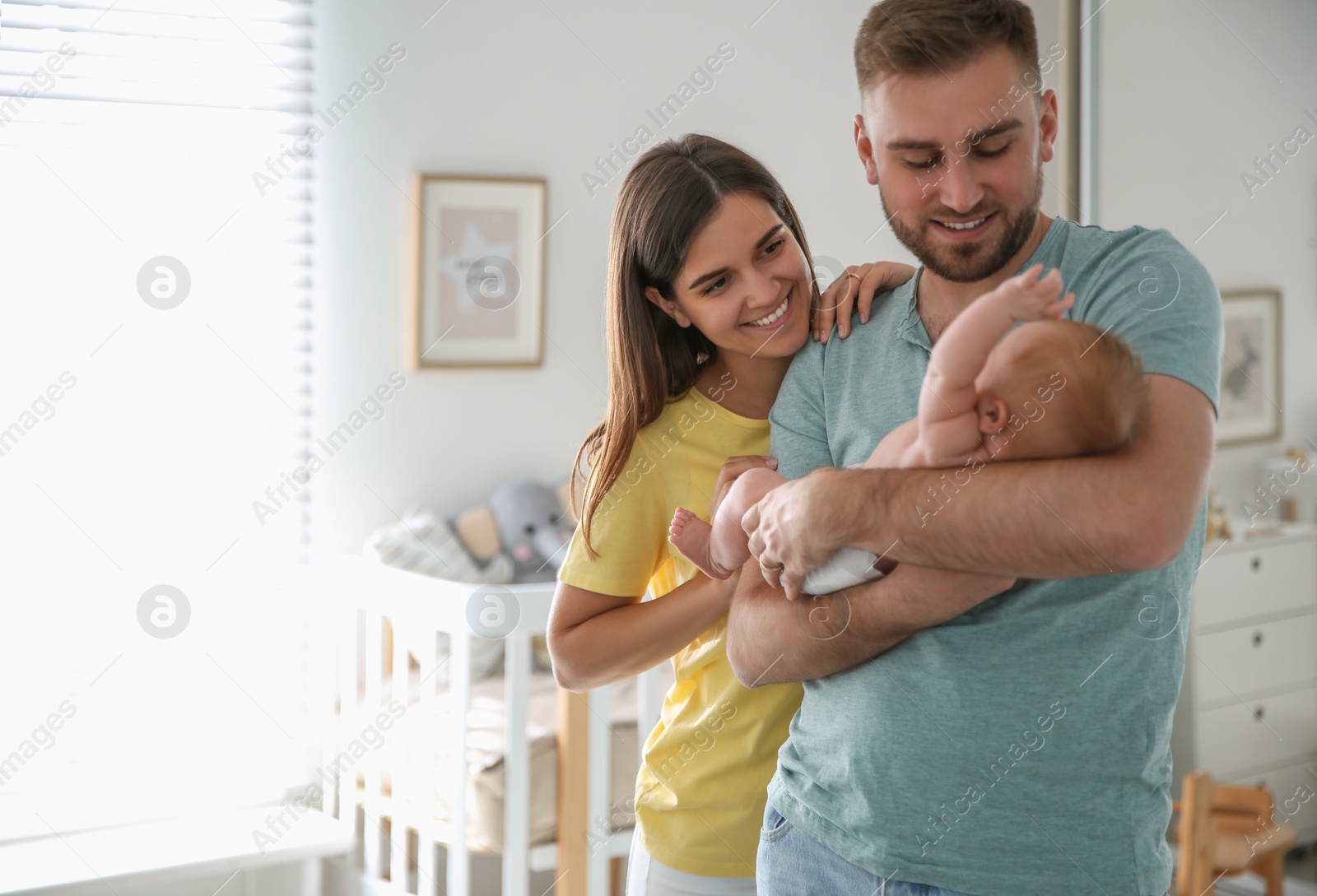 Photo of Happy couple with their newborn baby at home. Space for text