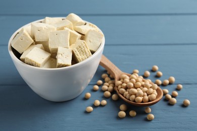 Photo of Cut tofu and soya beans on blue wooden table, closeup