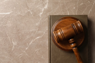 Photo of Wooden gavel and book on table, top view. Law concept