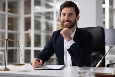 Photo of Portrait of smiling lawyer at table in office