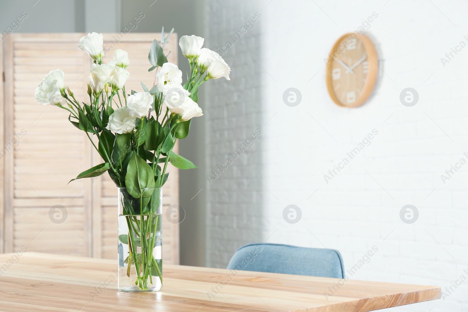 Photo of Vase with beautiful flowers as element of interior design on table in room. Space for text