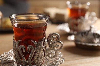 Photo of Glass of traditional Turkish tea in vintage holder on table, closeup. Space for text