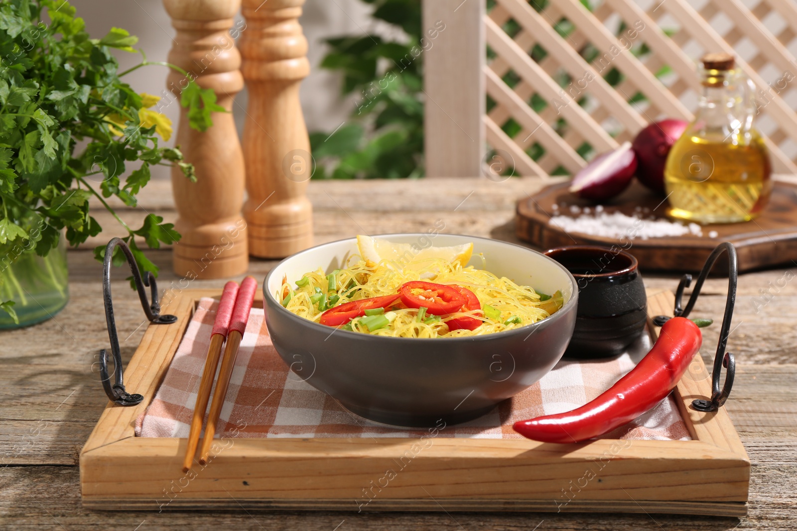 Photo of Stir-fry. Tasty noodles with vegetables and meat in bowl served on wooden table