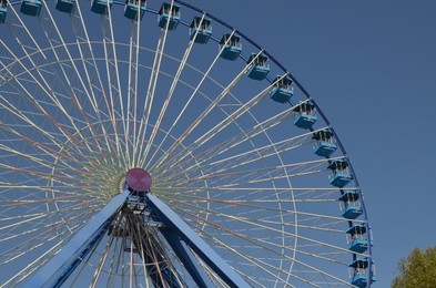 Photo of Amusement park. Beautiful Ferris wheel against blue sky, low angle view