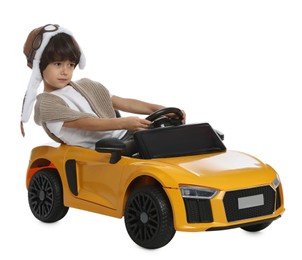 Photo of Cute little boy in pilot hat driving children's electric toy car on white background