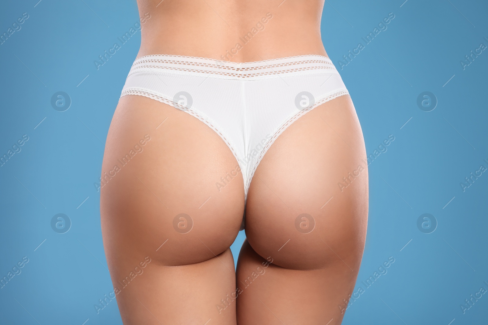 Photo of Closeup view of slim woman in underwear on light blue background. Cellulite problem concept