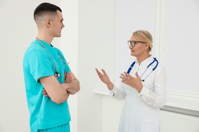 Medical doctors in uniforms having discussion indoors