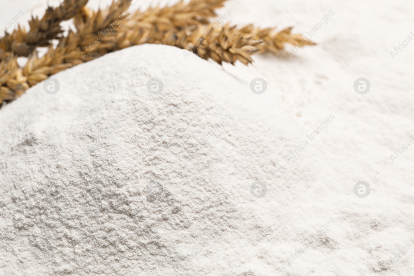 Photo of Spikes on wheat flour as background, closeup