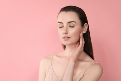 Photo of Portrait of beautiful young woman on pink background. Space for text