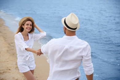 Happy couple having romantic walk on beach