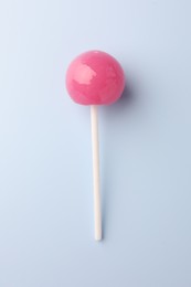 One tasty lollipop on light blue background, top view