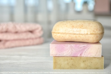 Photo of Stack of different soap bars on table. Space for text