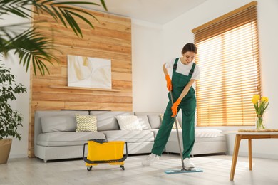 Photo of Woman cleaning floor with mop at home