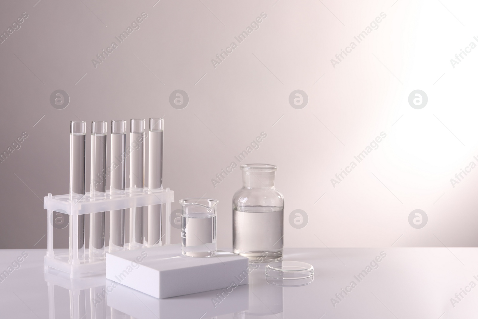 Photo of Laboratory analysis. Different glassware on table against light background, space for text