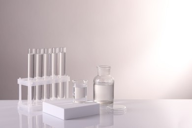 Photo of Laboratory analysis. Different glassware on table against light background, space for text