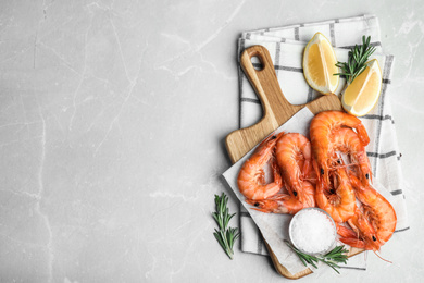 Delicious cooked shrimps with rosemary and salt on grey marble table, flat lay. Space for text