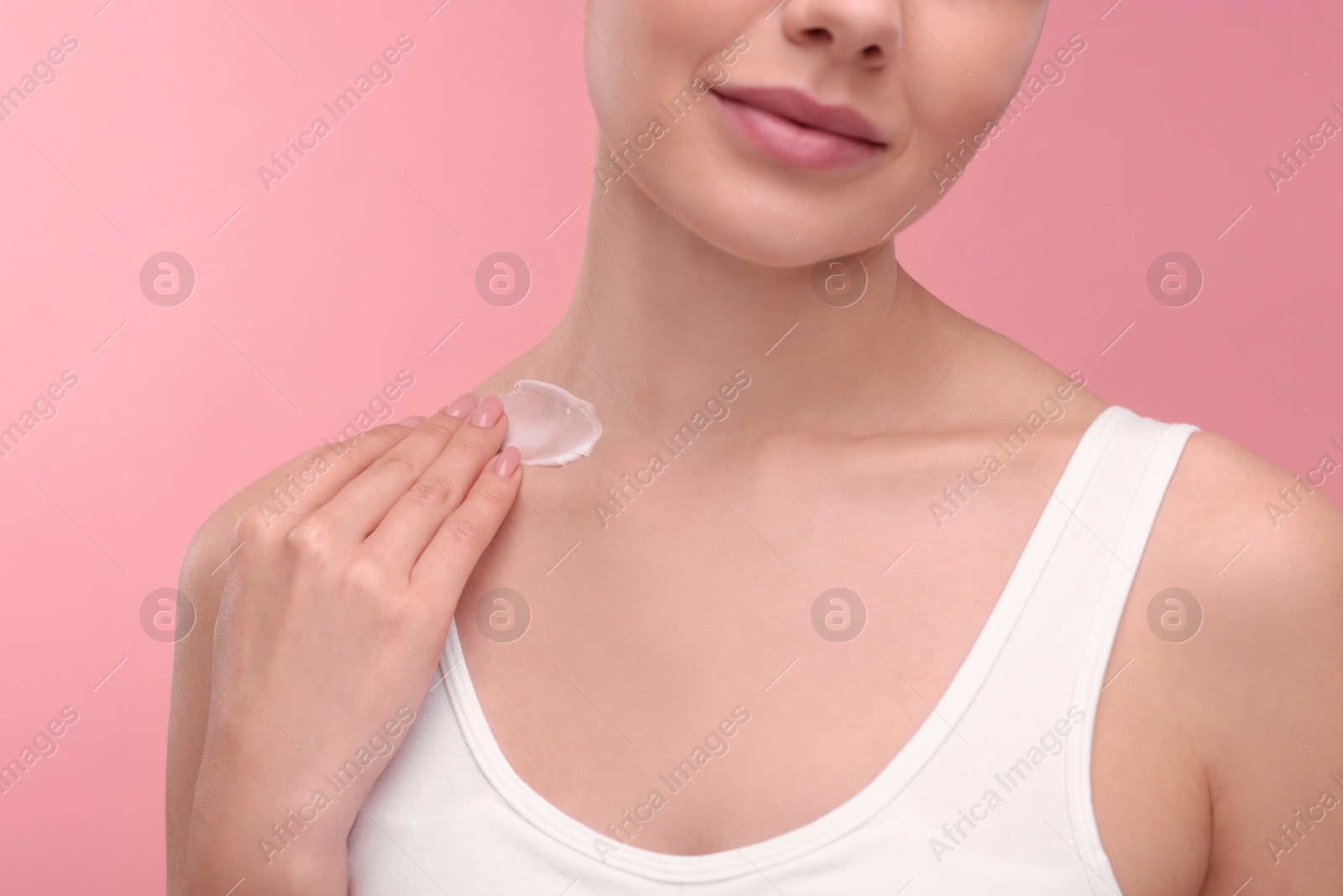 Photo of Woman with smear of body cream on pink background, closeup