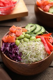 Photo of Delicious poke bowl with vegetables, fish and edamame beans on wooden table, closeup
