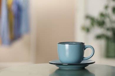 Photo of Ceramic cup on table in room, space for text