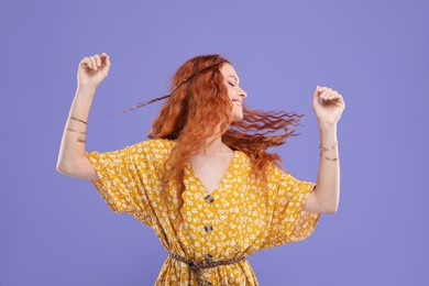 Photo of Beautiful young hippie woman dancing on violet background