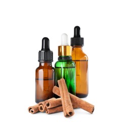 Image of Bottles of natural essential oil and dry cinnamon sticks on white background