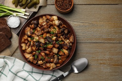 Tasty fried cracklings on wooden table, flat lay with space for text. Cooked pork lard