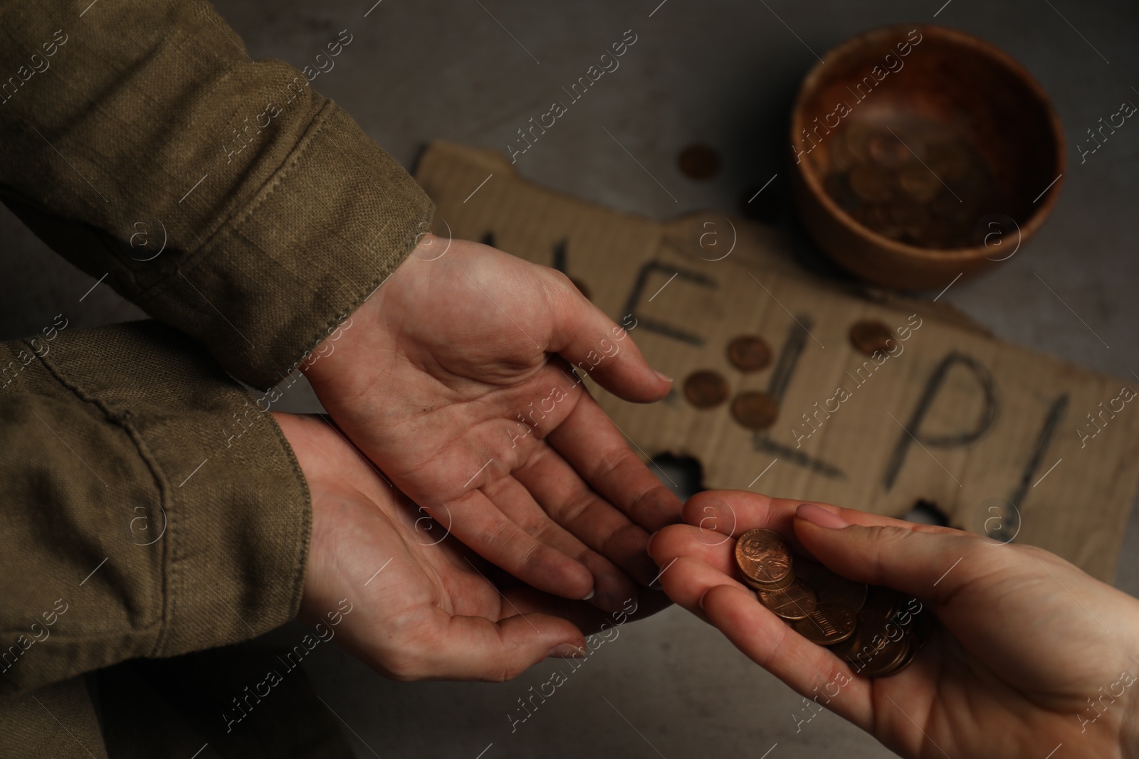Photo of Woman giving coins to homeless, closeup. Charity and donation