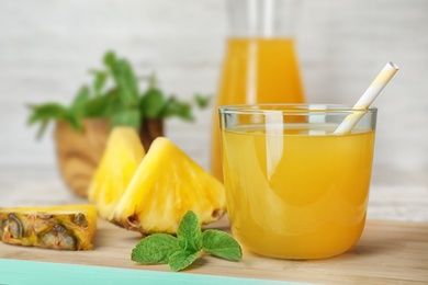 Photo of Glass with delicious pineapple juice on table