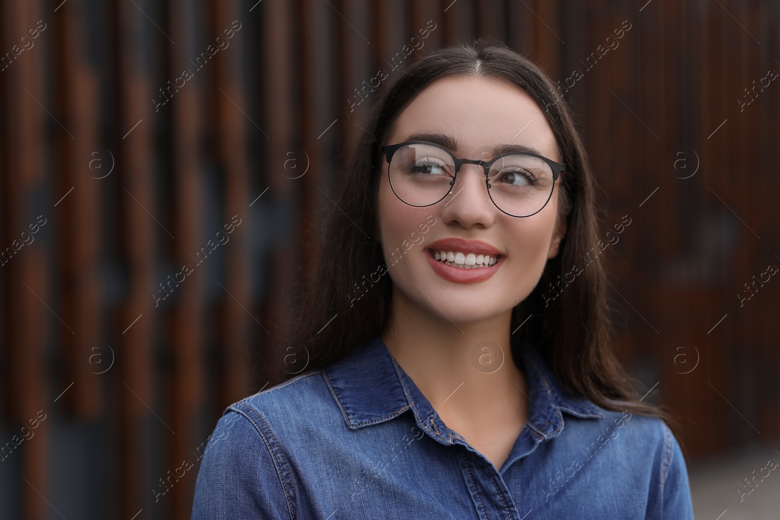 Photo of Portrait of beautiful woman in glasses on blurred background. Attractive lady smiling and posing for camera. Space for text