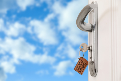 Image of Closeup view of door with key and blue sky on background