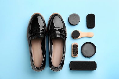 Flat lay composition with shoe care accessories and footwear on light blue background