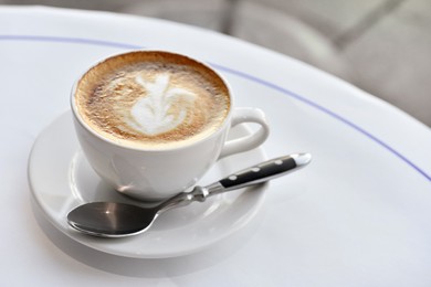 Photo of Cup of fresh coffee on round table in morning, space for text