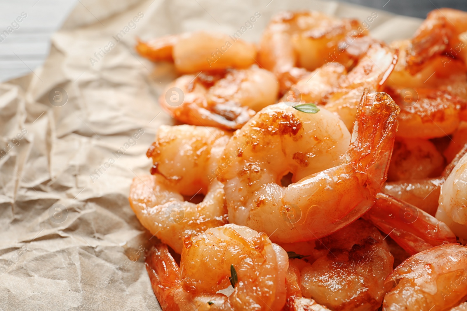 Photo of Delicious fried shrimps on parchment, closeup