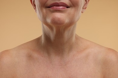 Photo of Mature woman with healthy skin on beige background, closeup