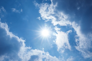 View of beautiful blue sky with fluffy clouds and sun