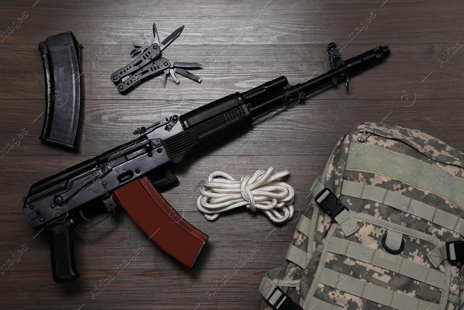Photo of Flat lay composition with gun and military knapsack on wooden table