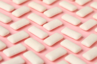 Many chewing gum pieces on pink background, closeup