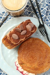 Round croissants served with coffee on table, flat lay. Tasty puff pastry