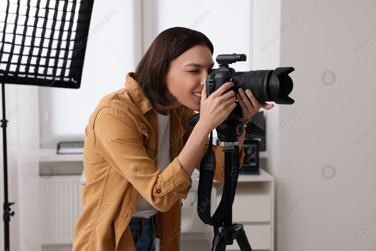 Photo of Professional photographer taking picture in modern photo studio