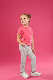 Cute little girl posing on pink background